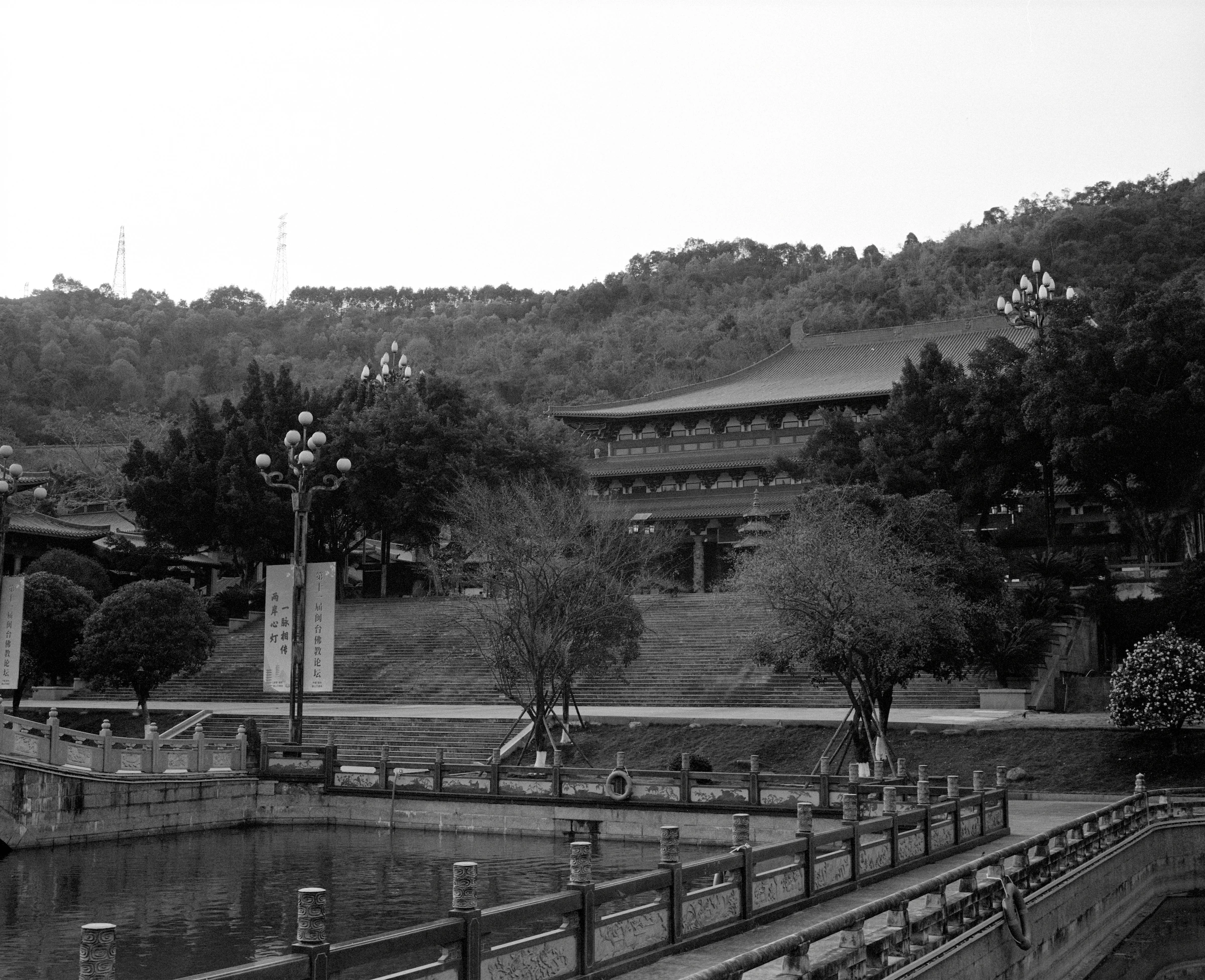 福建福州池畔木栏步道通向树木之间的传统建筑