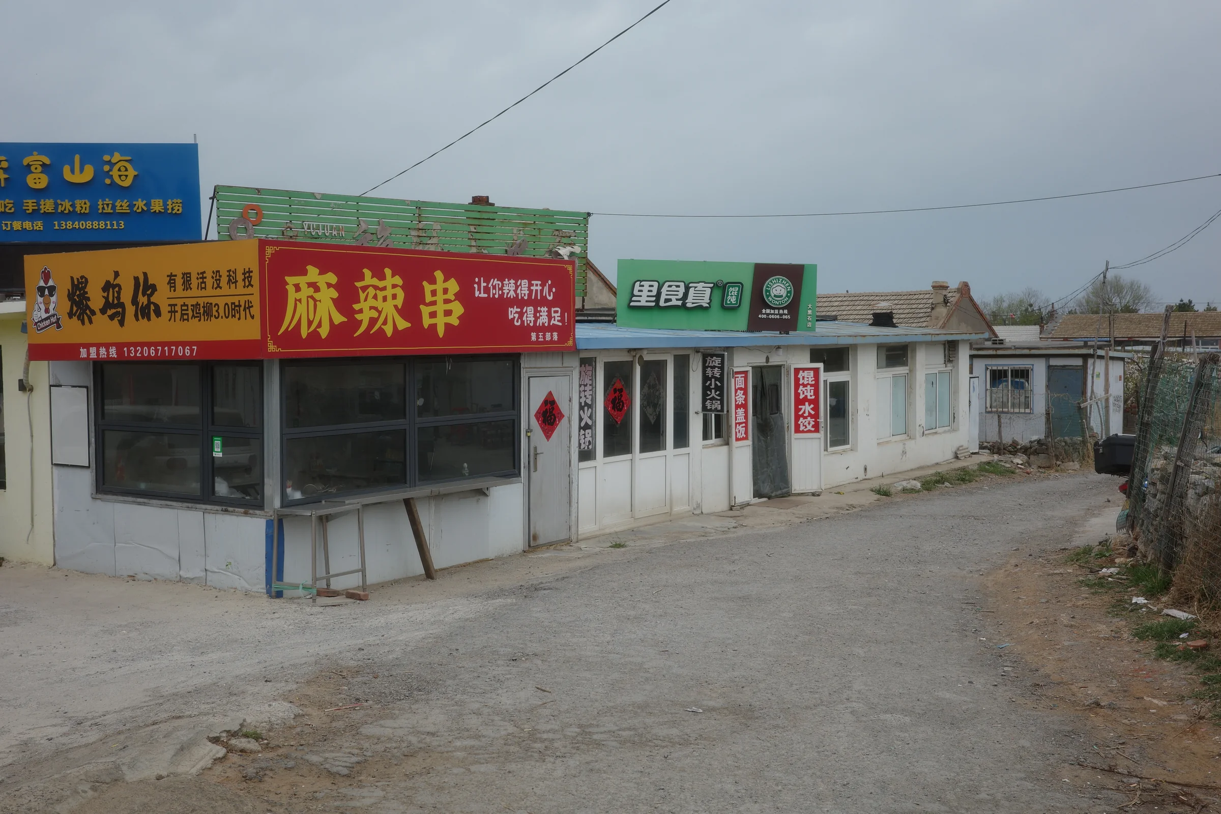 山东沿海村落土路旁的小店与彩色招牌